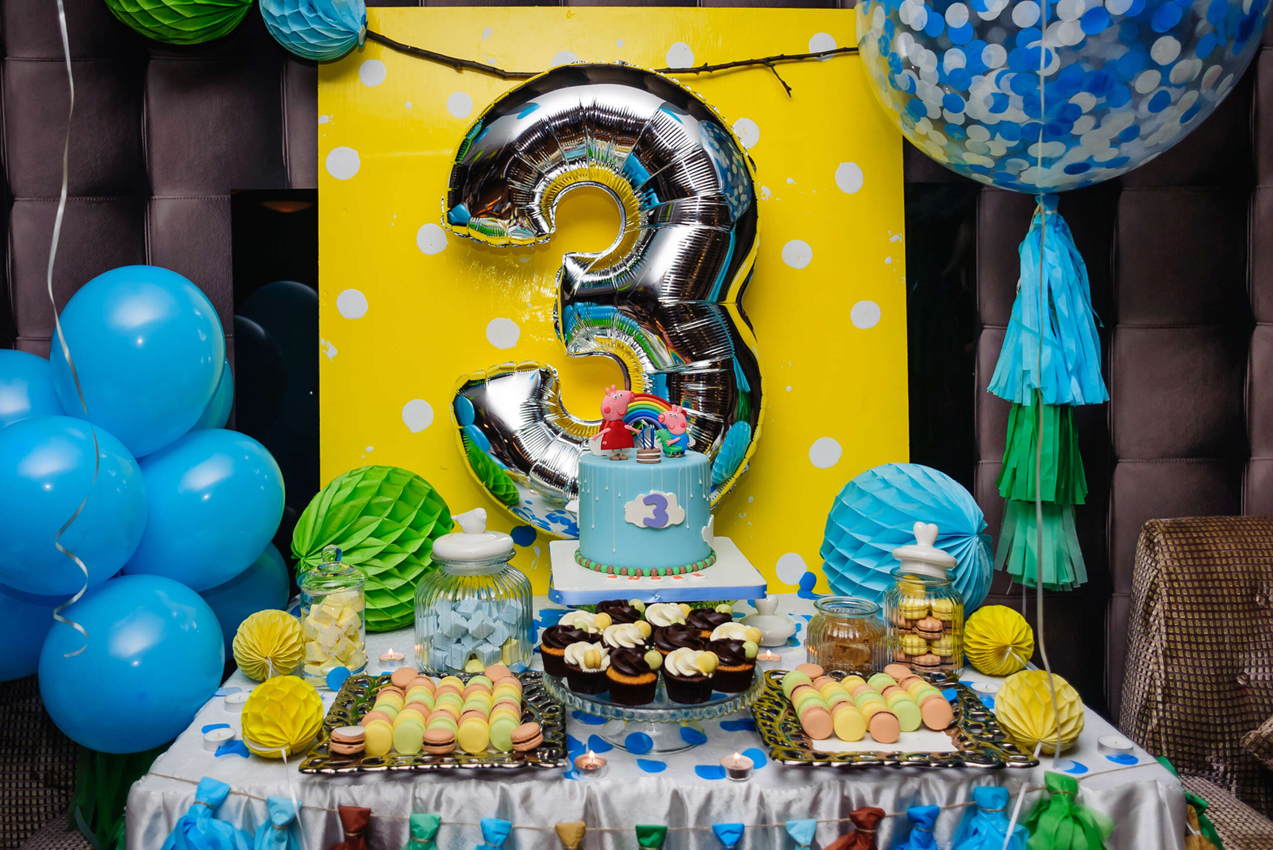 A candy bar with sweets and balloons in Peppa pig themes for birthday party.