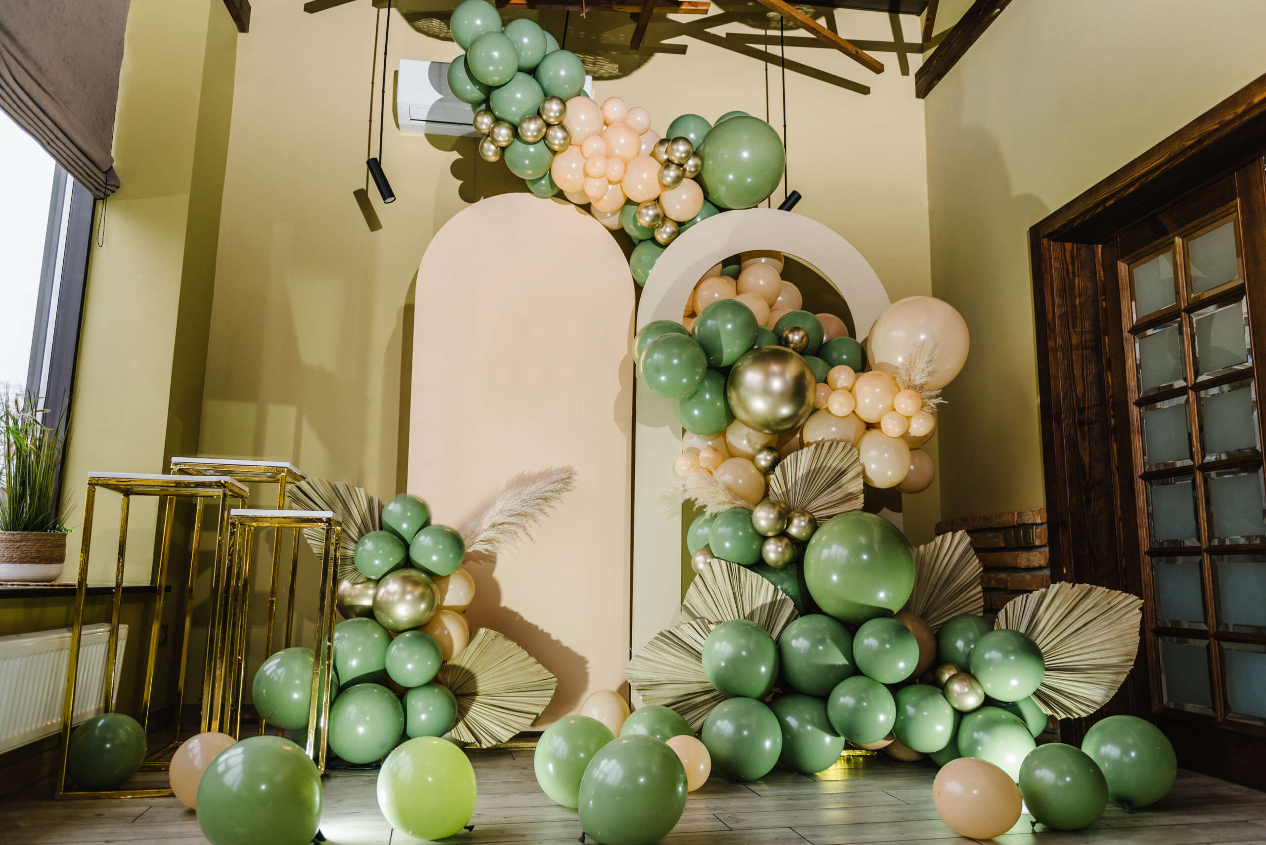 Arch decorated green, brown golden balloons, big paper decor lea